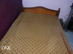 Brown Wooden Bed With Beige Bed Cover