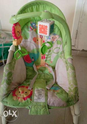 White, Green, And Orange Bouncer Seat