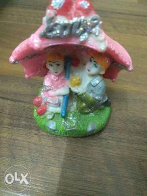 Man And Woman Under Pink Umbrella Ceramic Figurine