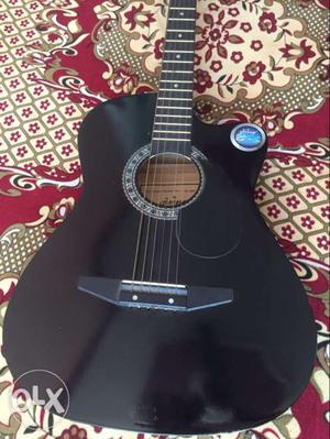 Jixing branded acoustic guitar with two picks.