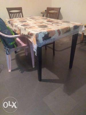 A wooden dining table with 3 chairs. unused.