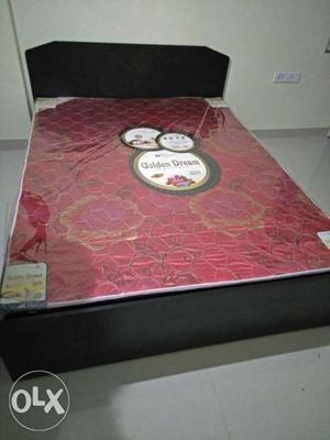 Red And Brown Floral Bed Mattress With Black Wooden Bed