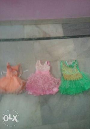 Girl's Orange, Pink, And Green Dresses