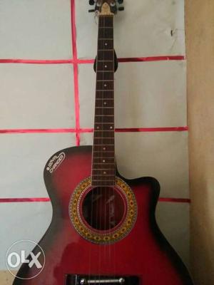 Red colour acoustic guitar with bag