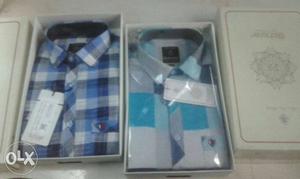 Two Blue And Gray Dress Shirts With Boxes
