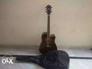 Brown Acoustic Guitar And Black Gig Bag