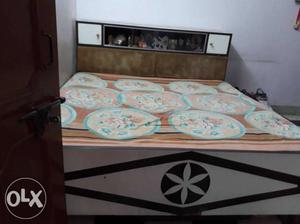 Brown Wooden Bed Frame With White And Blue Floral Mattress
