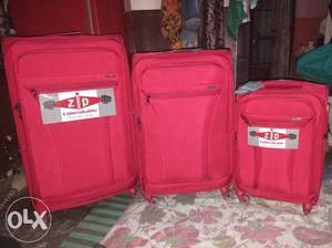 Three Red Zip Luggage Bags