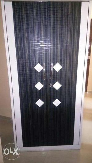 A black and white double door wooden wardrobe,