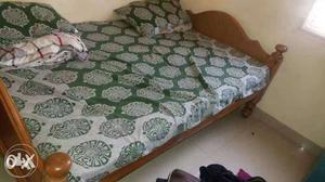 Brown Wooden Bed And Green And White Damask Print Bed Linen