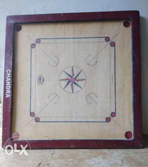 Carrom board with coins and striker. place: