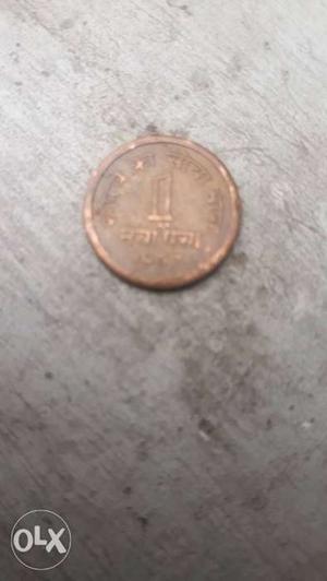 Round Gold-colored 1 Indian PAISA Coin.