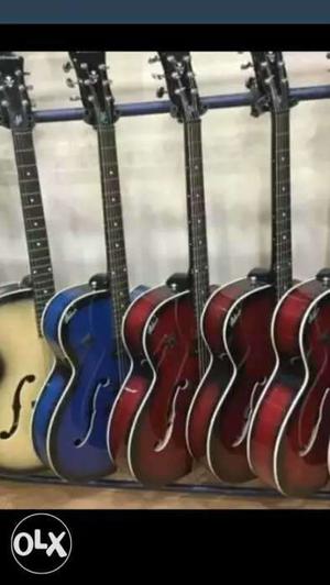 Three Red, One Blue, And One Brown Jazz Guitars