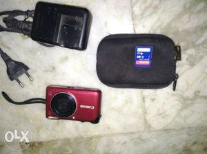 Red Canon Point-and-shoot Camera With Black Bag