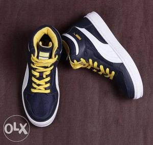 Pair Of Black-white-and-yellow PUMA High-top Sneakers.