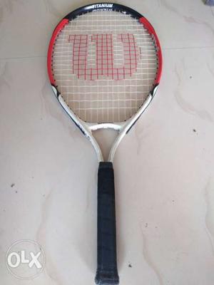 White, Red, And Black Wilson Tennis Racket