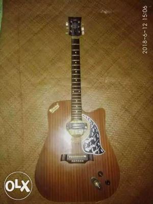 Brown Acoustic Guitar and Jambo Size of Kriston Guiter.