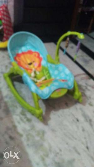Green and blue fisher price bouncer in a brand