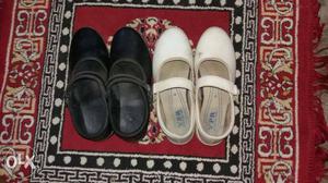 Two Pairs Of White And Black Slip-on Shoes