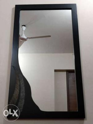 Wooden mirror frame with leaf detailing.