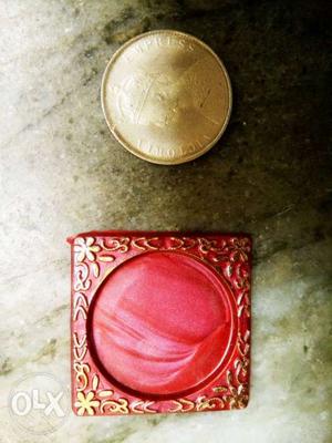 Round Gold-colored Coin And Red Case