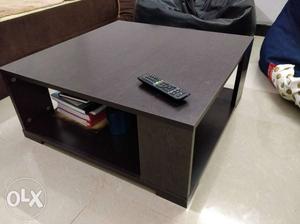 A medium sized coffee table, about one feet in