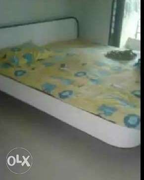 White Wooden Bed With Striped Mattress