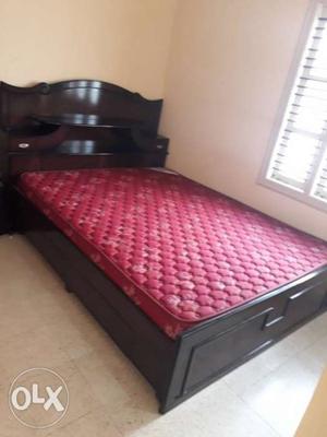 Black Wooden Bed Frame And Red Mattress
