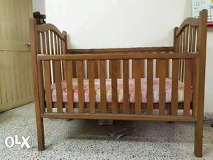 Baby's Brown Wooden Crib With Pink, Yellow, And Red Floral