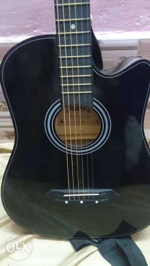 Black Acoustic Guitar With Capo