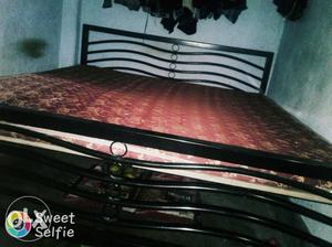 Black Metal Bed And Brown And Maroon Floral Bedspread