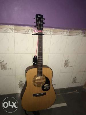 A cort acoustic guitar with natural mat colour