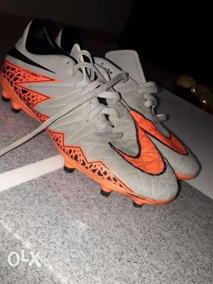 Pair Of grey-and-orange Nike football Shoes