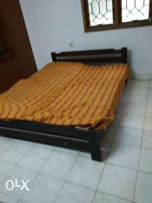 Brown Wooden Bed Frame With Red Bed Sheet