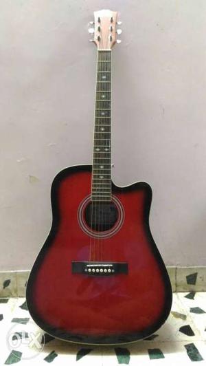 Good condition. Red and black guitar with a cover and pick.