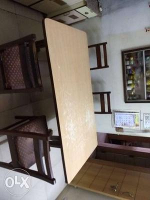 Wooden dining table with four chairs in excellent condition.