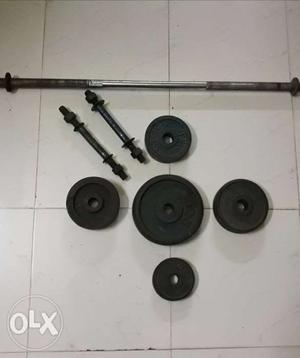 Five Black Weight Plates And Barbell And Two Dumbbell Bars