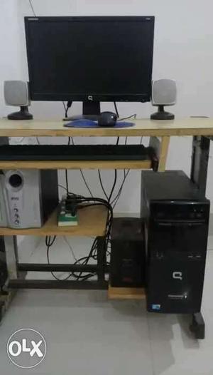 Compaq computer with table and intex sound box..