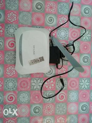 White And Gray TP-Link Wireless Router With Black AC Adapter