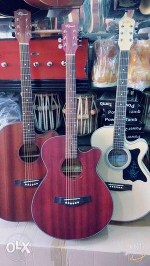 Three Red, Brown, And Beige Acoustic Guitars
