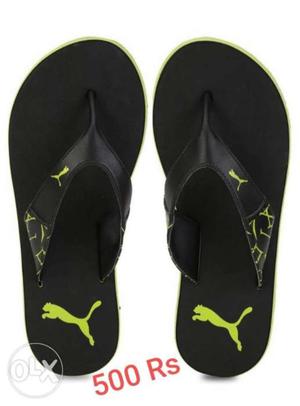 Pair Of Black-and-green Puma Sandals With Text Overlay