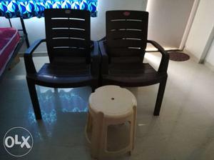 Two Black Armchairs And Beige Plastic Stool