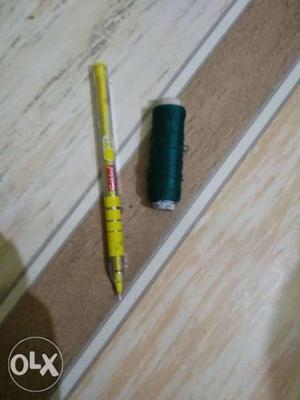 Yellow Ballpoint Pen And Black Sewing Thread