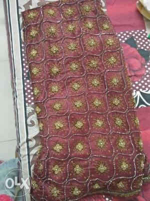 Coffee maroon color net full bridal lehnga with duptta.