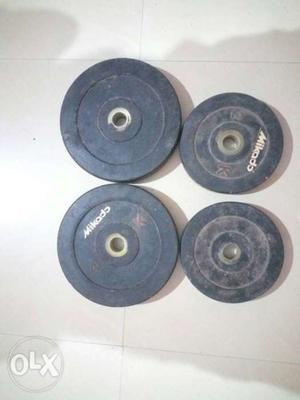 Four Black Weight Plates With Barbell