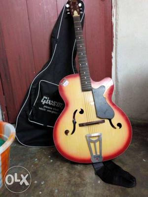 Givson Brown, Orange, And Yellow Acoustic Guitar With Guitar