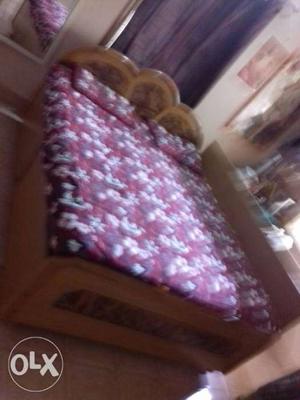 Brown Wooden Bed Frame With Purple And White Floral Mattress