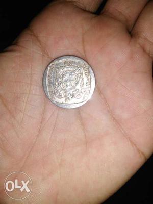 Person Holding Round Silver-colored Coin