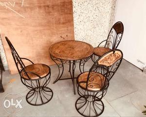 Wrought iron table with wooden carving top along