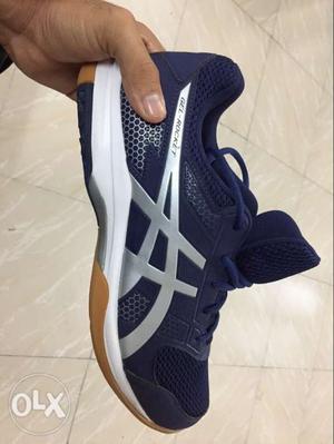Person Holding Gray And Black Asics Shoe